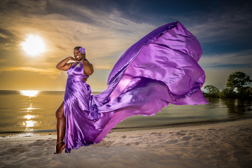 Woman in a flying dress on the beach at sunset in San Pedro, Belize